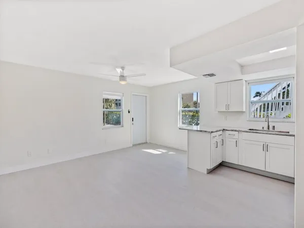 a kitchen with stainless steel appliances kitchen island a refrigerator sink and cabinets