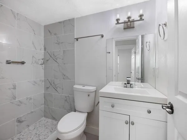 a view of backyard of house with table and chairs and a large tree