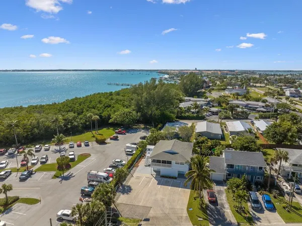 an aerial view of a city with lots of residential buildings ocean and mountain view in back