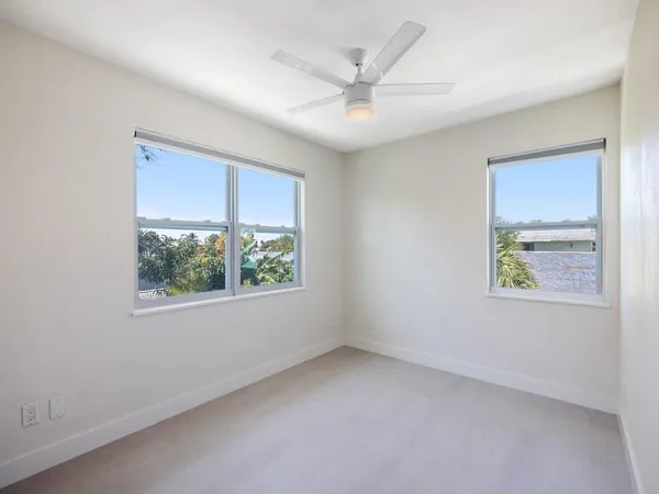 an empty room with windows and closet