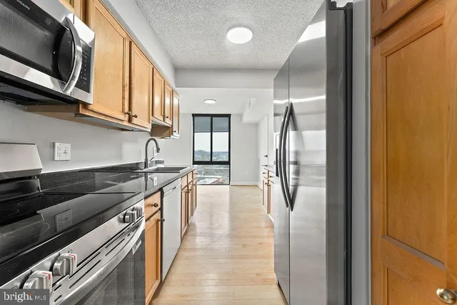 a kitchen with stainless steel appliances granite countertop a refrigerator and a stove top oven