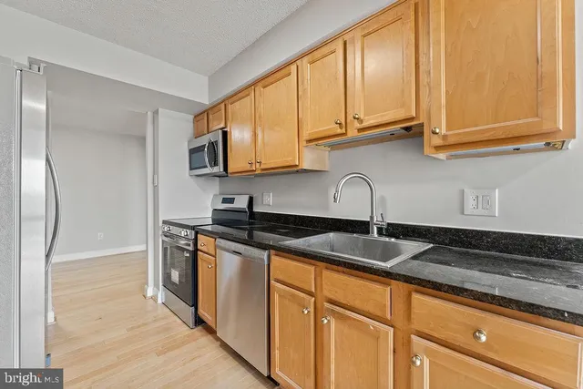 a kitchen with stainless steel appliances granite countertop a sink and a microwave