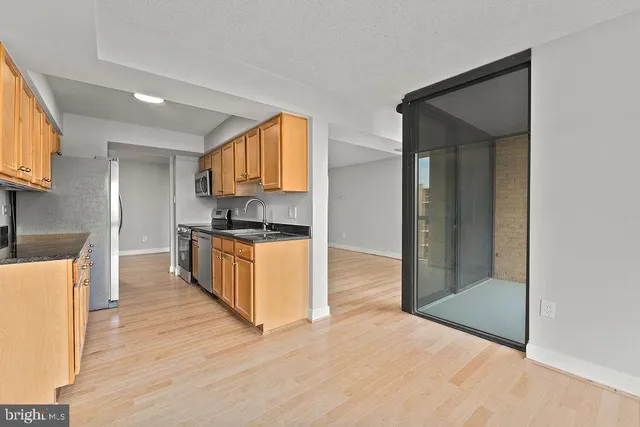 a kitchen with granite countertop a refrigerator and a stove top oven