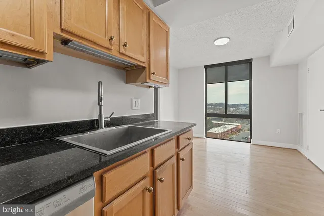 a kitchen with stainless steel appliances granite countertop a sink and a white cabinets