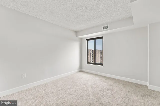 an empty room with windows and closet