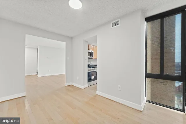 a view of empty room with wooden floor and entryway
