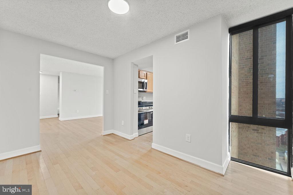 4500 South Four Mile Run Drive, Unit 1113 Arlington, VA 22204 - Photo 10 of 36 a view of empty room with wooden floor and entryway
