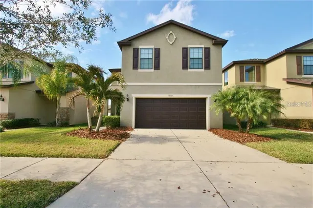 a front view of a house with a yard and garage