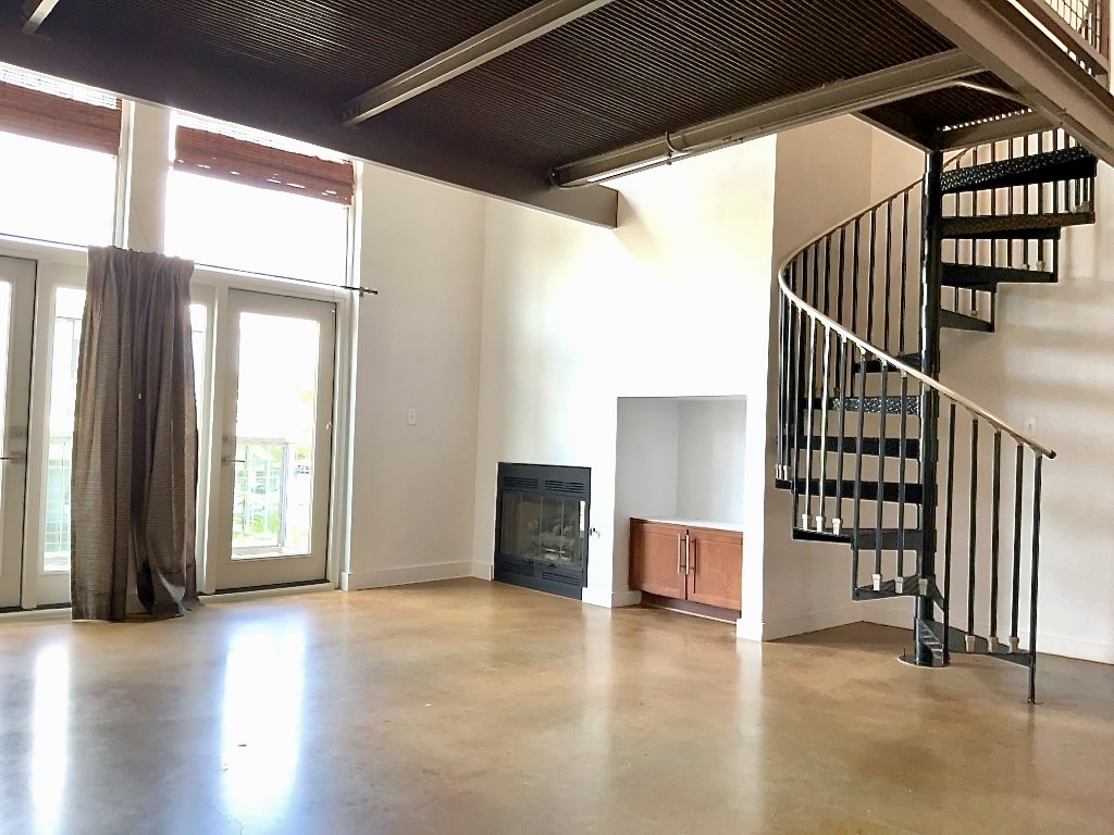 1601 East Cesar Chavez Street, Unit 306 Austin, TX 78702 - Photo 3 of 19 a view of an empty room with wooden floor and stairs