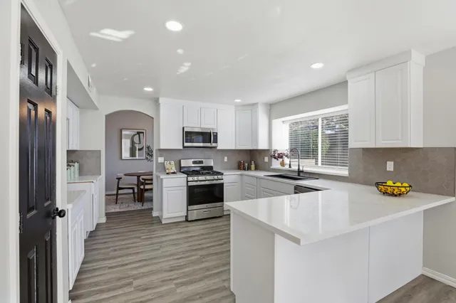 a kitchen that has a lot of cabinets a sink and appliances in it