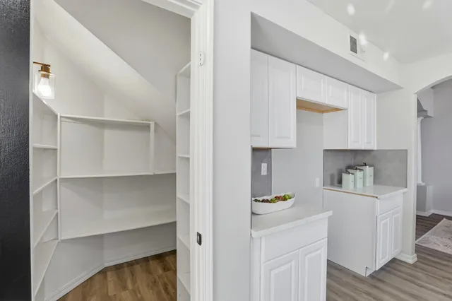 a hallway with cabinets and wooden floor