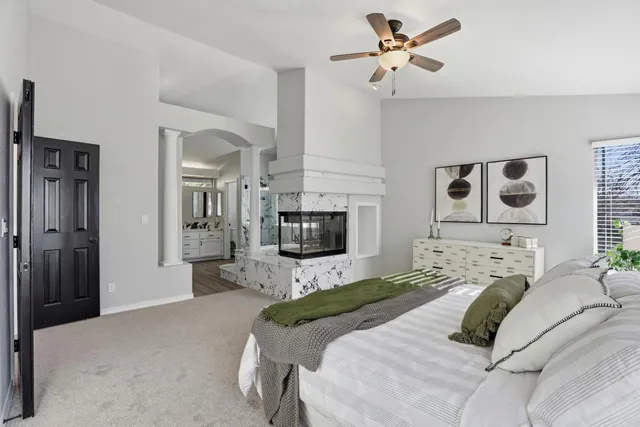 a bedroom with a bed couch and a flat tv screen