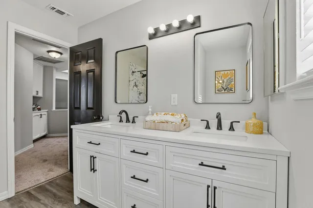a bathroom with double sink and a mirror