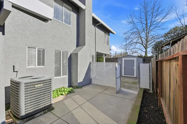 a backyard of a house with flower plants and wooden fence