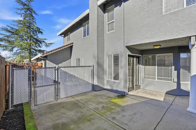 a view of backyard with a table and chair under an umbrella