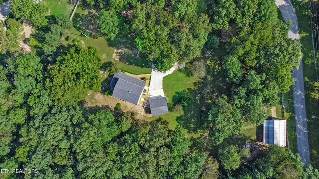 an aerial view of a house with a yard and outdoor seating