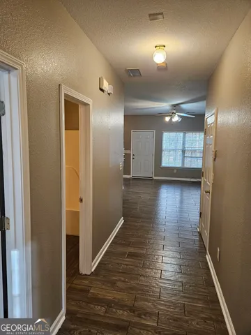 a view of a hallway with wooden floor