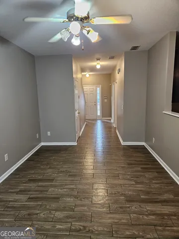 a view of an empty room with wooden floor