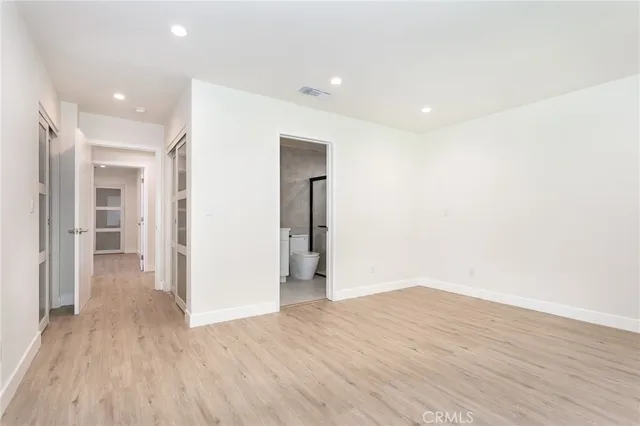 a view of a big room with wooden floor and windows