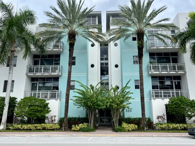 a front view of multi story residential houses with yard and green space