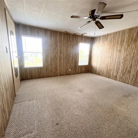 en empty room with windows and fan