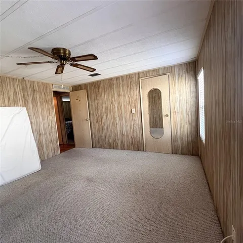 en empty room with windows and fan