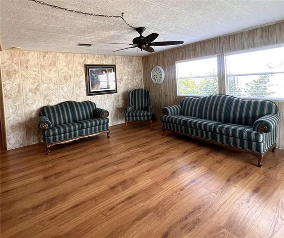 a living room with furniture ceiling fan and a window