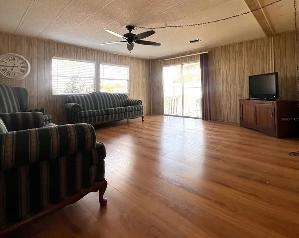 a living room with furniture windows and a flat screen tv