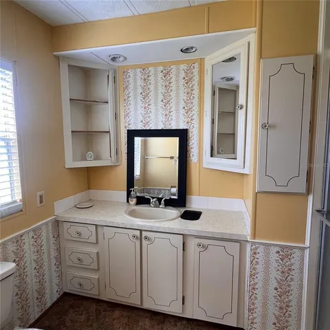 a bathroom with a granite countertop sink and a mirror