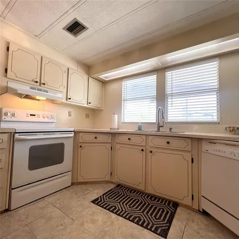 a kitchen with granite countertop a stove sink and cabinets