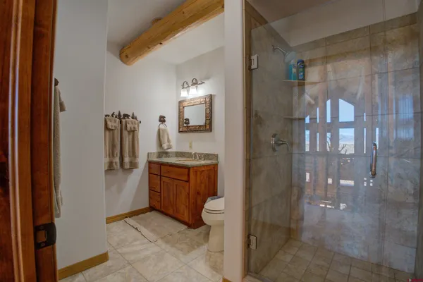a bathroom with a granite countertop sink a toilet and shower