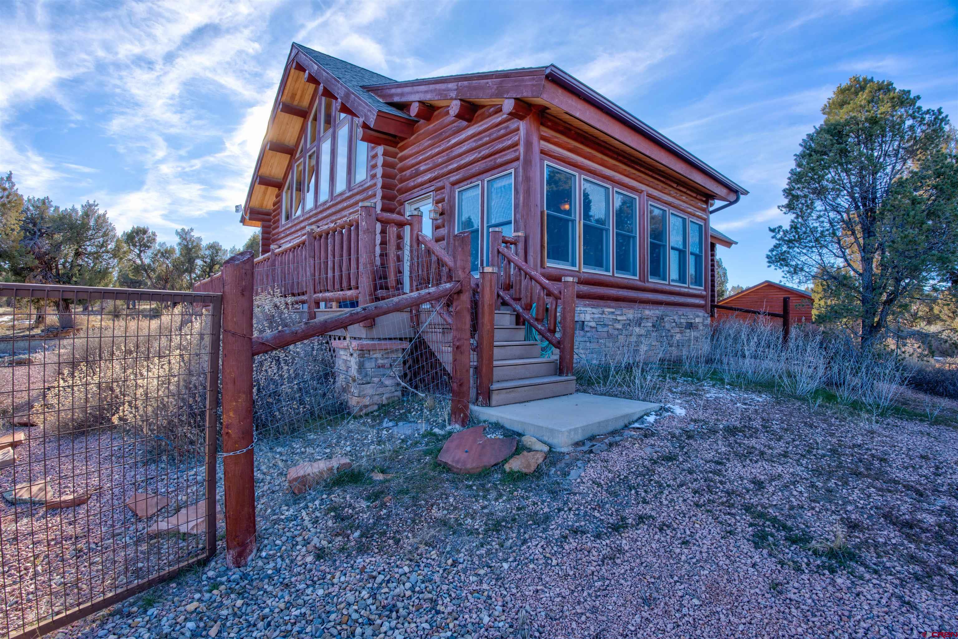 9619 Pueblo Ruins Road Cortez, CO 81321 - Photo 6 of 40 a backyard of a house with plants and wooden fence