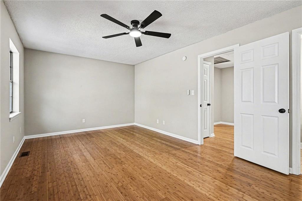 6052 WinterGreen Road Northwest Norcross, GA 30093 - Photo 15 of 24 an empty room with wooden floor and a ceiling fan