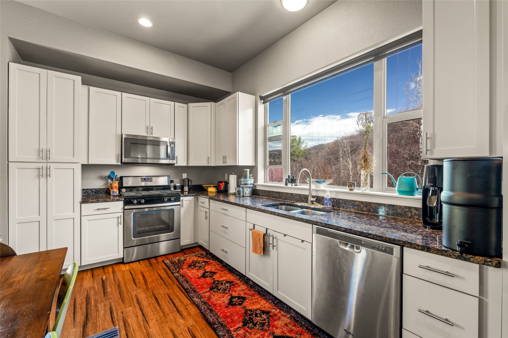 1680 Copper Ridge Drive, Unit 101 Steamboat Springs, CO 80487 - Photo 12 of 21 a kitchen with stainless steel appliances granite countertop a stove sink and cabinets