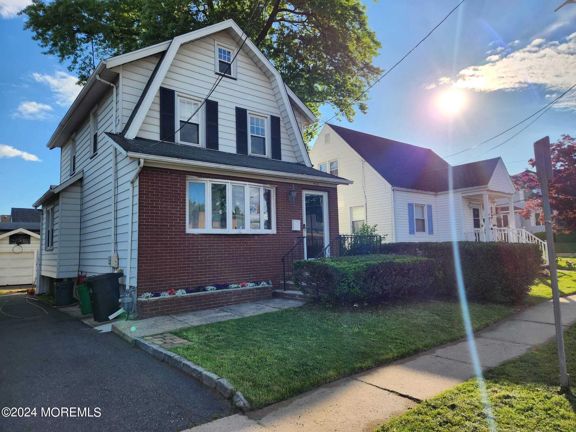 406 Rutherford Avenue Lyndhurst, NJ 07071 - Photo 1 of 5 a front view of a house with a yard and garage
