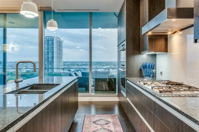a kitchen with stainless steel appliances granite countertop a sink stove and cabinets