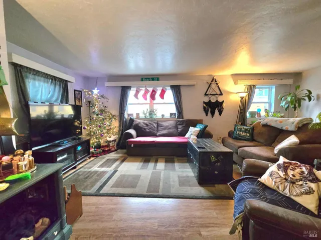 a living room with furniture and a wooden floor