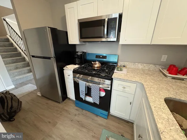 a kitchen with stainless steel appliances granite countertop a stove a microwave and a refrigerator