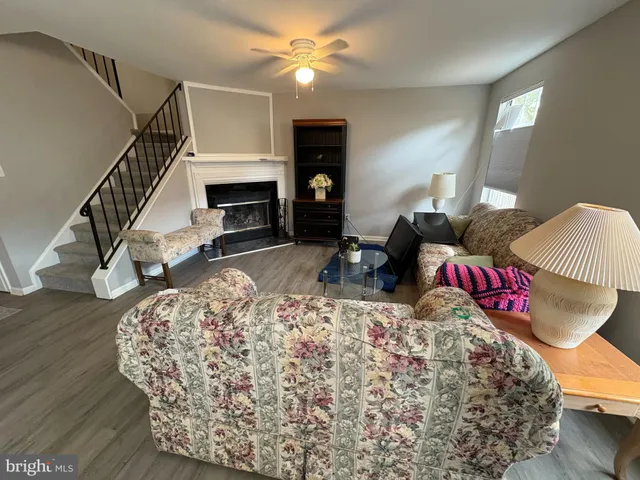 a living room with furniture a fireplace and wooden floor