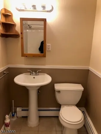 a bathroom with a toilet a sink and mirror