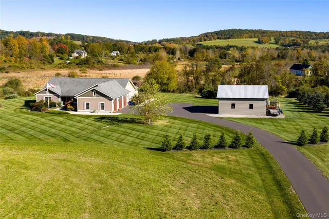 an aerial view of residential houses with outdoor space and trees