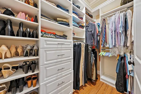a view of walk in closet with clothes and shoes
