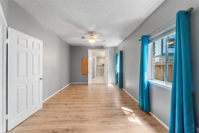 a view of an empty room with closet and windows
