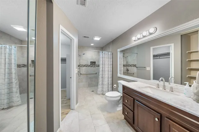 a bathroom with a sink a toilet and shower