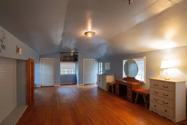 a view of empty room with wooden floor and fireplace