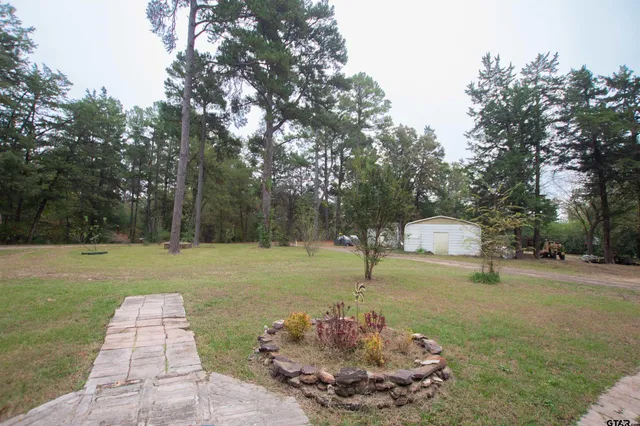 a view of a house with a tree and wooden fence