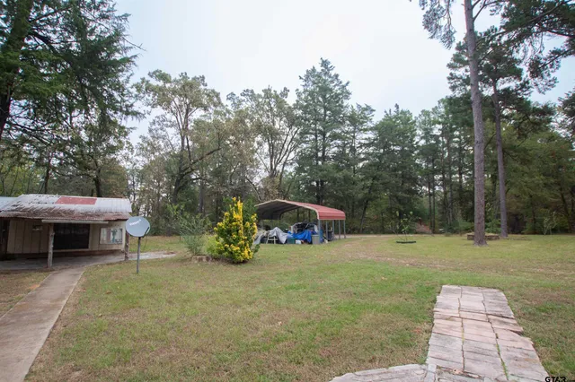 a view of house with backyard and porch