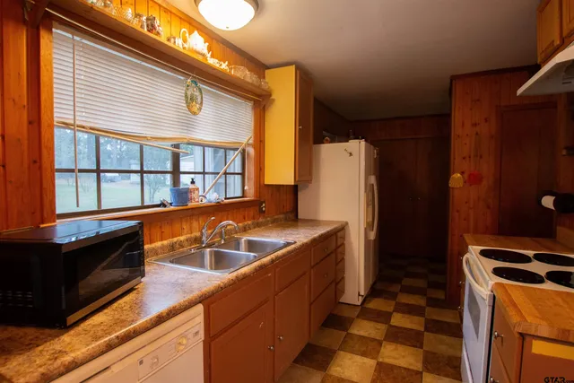 a kitchen with stainless steel appliances granite countertop a sink and a refrigerator