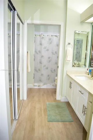 a bathroom with a sink a toilet a mirror and shower
