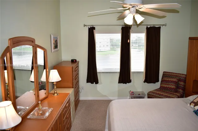 a bedroom with a large bed and ceiling fan
